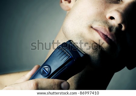 Fashion portrait of male chin and electric shaver