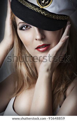 Fashion portrait of young sexy woman with red lips and captain cap