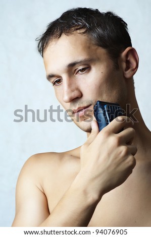 Fashion portrait of man shaved his chin by electric shaver