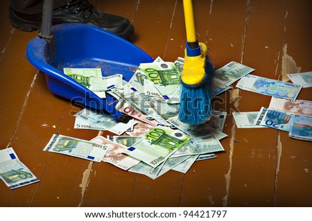 Person sweeping euro money banknotes with a broom to scoop