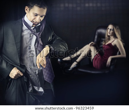 Checking the time. Worried young business man is late. Or man run away from his mistress, quickly dressed to get somewhere in time