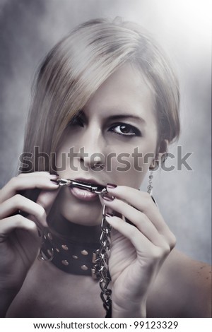 Beautiful Woman with chain in her mouth. Make up and manicure