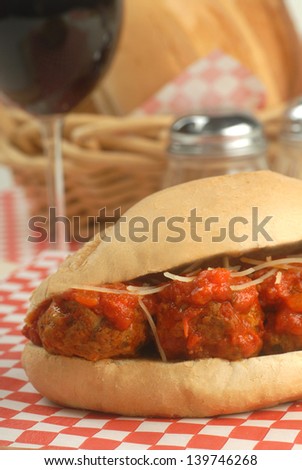 Delicious meatball sandwich with marinara sauce, cheese and wine.
