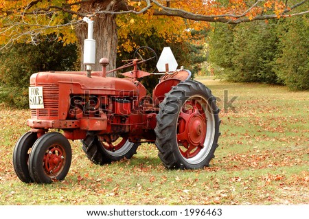 Red antique tractor in rural setting with autumn colors