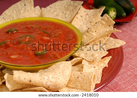 Bowl of salsa with tortilla chips with Jalapeno peppers