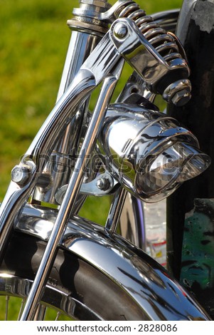 The front of a motorcycle showing chrome fender and light