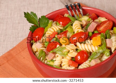 A fresh pasta salad in a red bowl