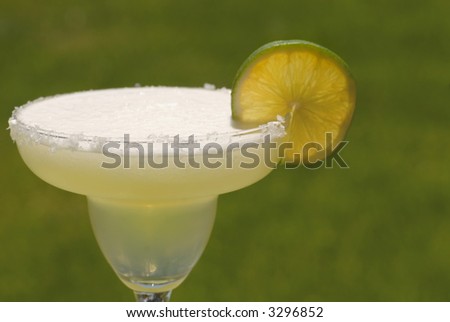 A margarita with a salt rimmed glass and a slice of lime