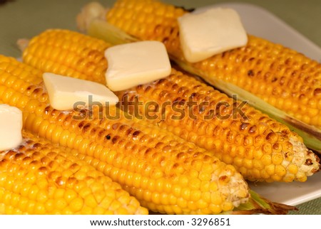 Four ears of roasted corn with butter