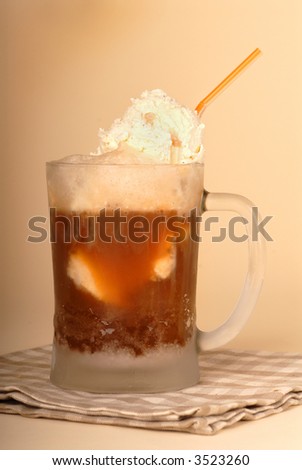A root beer float in frosted glass and straw