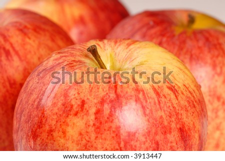 Four organic gala apples with a shallow depth of field