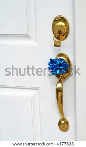 A lock and handle on door of new home with a bow on the handle