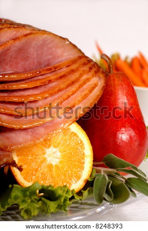 An Easter honey and brown sugar glazed ham with carrots and herbs