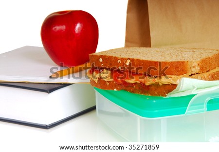 School lunch showing book, pencil, peanut butter sandwich