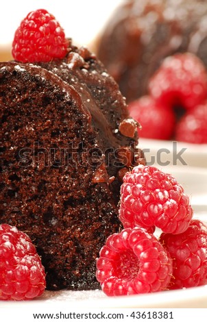 Fresh chocolate fudge cake with raspberries, powdered sugar in a romantic holiday setting