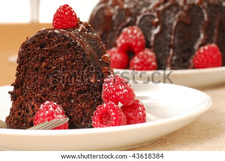 Fresh chocolate fudge cake with raspberries and powdered sugar in a romantic holiday setting
