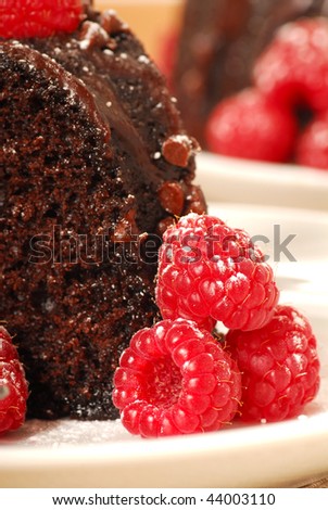 Closeup of a chocolate fudge cake with raspberries in a holiday setting