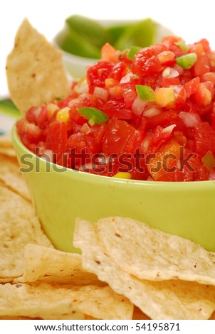 Freshly made tortilla chips with a corn and tomato salsa with limes