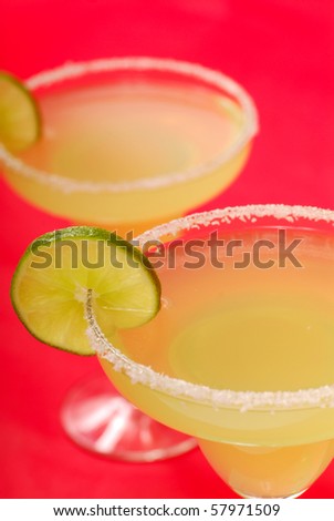 Two refreshing Margaritas with slices of lime on salt rimmed glasses
