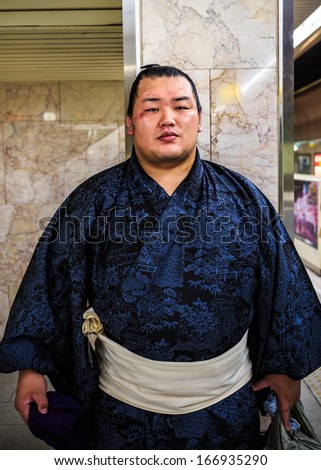 FUKUOKA, JAPAN - NOVEMBER 13: Sumo wrestler in Fukuoka, Japan on November 13, 2013. Unidentified Japanese Sumo wrestler waits for a train to his tournament at Fukuoka Sumo arena