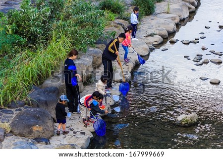NAGASAKI, JAPAN - NOVEMBER 14: Nakashima River in Nagasaki, Japan on November 14, 2013. Teachers take small students to pick garbage from the river as an activity for environmental learning process