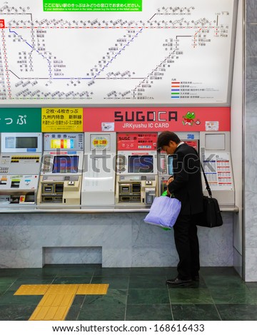 FUKUOKA, JAPAN - NOVEMBER 14: Buying train ticket in Fukuoka, Japan on November 14, 2013. Unidentified man buys ticket from vending machine at Hakata Station