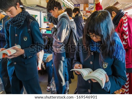 NARA, JAPAN - NOVEMBER 16: Japanese Students in Nara, Japan on November 16, 2013. Japanese students read their books for their examinations on a train to school