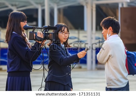 NARA, JAPAN - NOVEMBER 16: Japanese Students in Nara, Japan on November 16, 2013.  Unidentified Japanese students with camera have a workshop of interviewing people at Nara Station