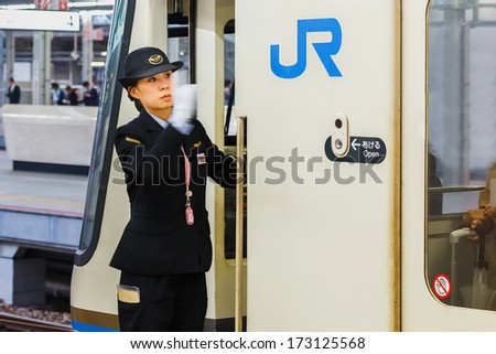 KOBE, JAPAN - NOVEMBER 17: Train Driver in Kobe, Japan on November 17, 2013. Unidentified Female train Driver gives a hand sign for passenger checking for passenger before leaving the platform