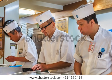 TOKYO, JAPAN - NOVEMBER 25: Japanese Sushi Chefs  in Tokyo, Japan on November 25, 2013. Unidentified Japanese Sushi - Sashimi Chefs prepare dishes of sushi for their customers in a restaurant