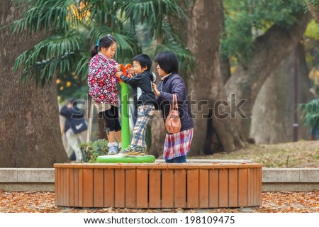 TOKYO, JAPAN - NOVEMBER 25: Ueno Park in Tokyo, Japan on November 25, 2013.  Young children with their mother play on a provided playground area in Ueno Park