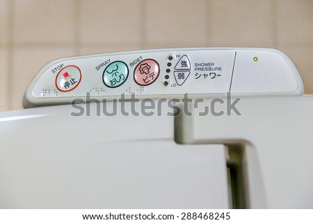 Osaka, Japan - October 29 2014: Western style toilets in Japan feature a heated seat, a built-in shower with brailler letters on the panel for the blind