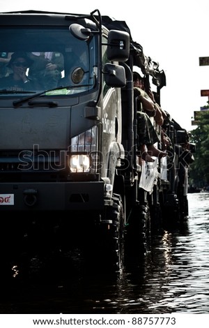BANGKOK - NOVEMBER 13: A line of military trucks carries officers to help people from  the flooded area at Sapan Mai district during the massive flood crisis on November 13, 2011 in Bangkok.