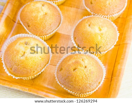 cakes in paper forms on a decorative tray