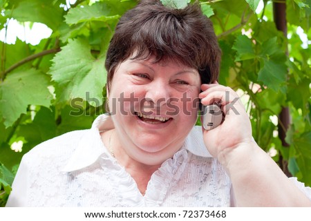 a woman middle-aged  on nature speaks by phone