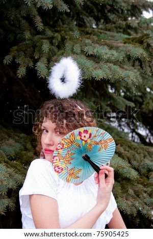 beautiful young woman with a rim of the head and fan in hand