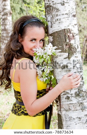 portrait of young beautiful woman on nature with colors in hands near a birch
