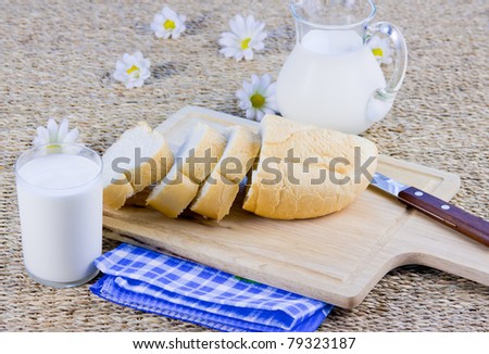 fresh cut long loaf and milk in a jug