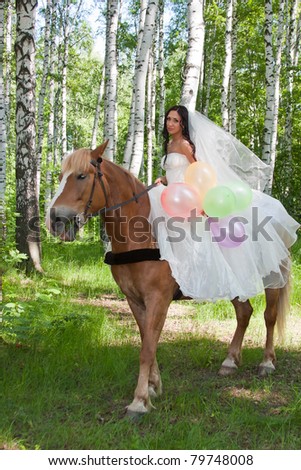 a young woman sits astride a horse in a wedding dress