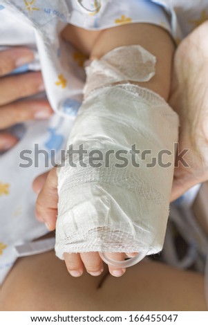 Closeup of nurse holding patients hand in hospital