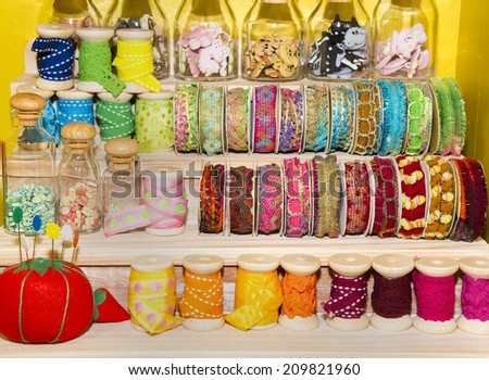 shelves of coloured ribbon reels and trims in fabric shop