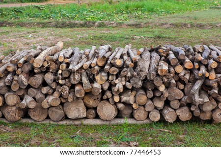 A lot of wooden stumps laying on a green field