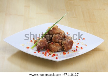 Fried thai appetizers with soy dipping sauce presented on a plate with banana leaf and scallion garnish.