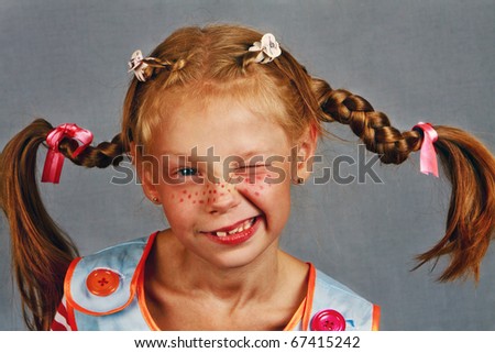 Red-Haired Girl with Upward Braids are winks Making  Face / Whimsical, color photo of a happy, red-haired girl with freckles and upward braids and a smile!