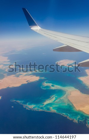 View from a plane window on the wing and the landscape below it