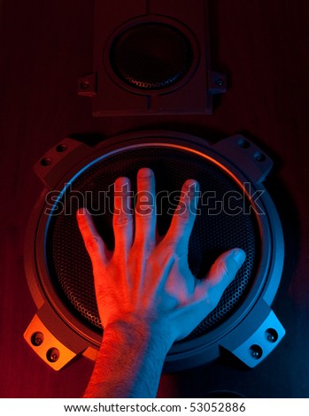 hand covers the speaker in colored light