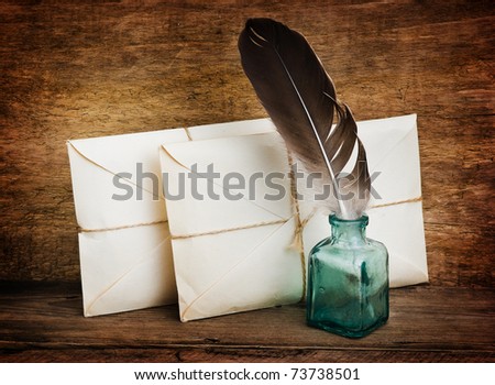 Postage on the background of an old wooden board with a pen for writing in the ink