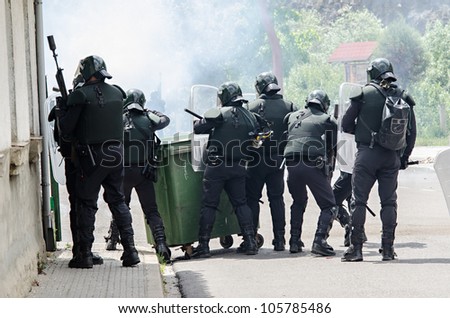 CIÑERA, SPAIN - JUNE 19:  Anti riot police agents of the Guardia Civil disperse striking miners shooting rubber balls and smoke cans on June 19th 2012 in Ciñera, Spain.