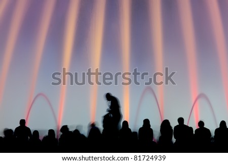 Magic fountains, Barcelona, Spain -  Silhouettes of people enjoying the colorful magic fountains in Barcelona, Spain, at night