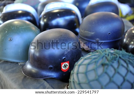 MILAN, ITALY - NOV 1: Military Nazism helmets, Exhibitor sitting in his stand at Militalia, exhibition dedicated to militaria collectors and military associations on November 1, 2014 in Milan.